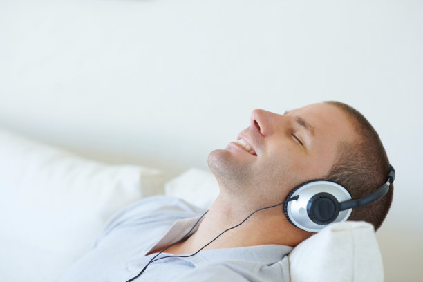 英俊的年轻人戴着耳机听音乐图片下载