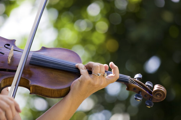 女小提琴家在一个阳光明媚的日子里在户外演奏图片下载