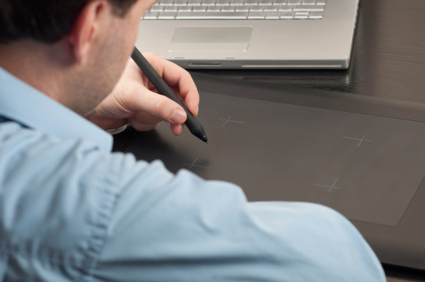 设计师在笔记本电脑前使用平板电脑工作图片下载