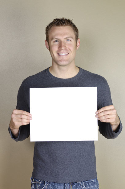 标志-英俊的男人拿着空白的白色标志。图片下载