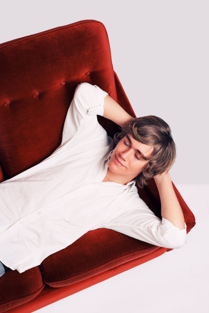 一个十几岁的男孩在沙发上休息图片下载