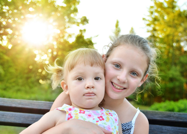 两个白种姐妹在公园拥抱微笑和有乐趣图片下载