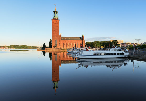 清晨的阳光倒映在水面上，斯德哥尔摩的Stadshuset。图片下载