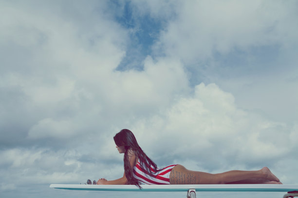 有纹身的女性躺在跳水板上图片下载