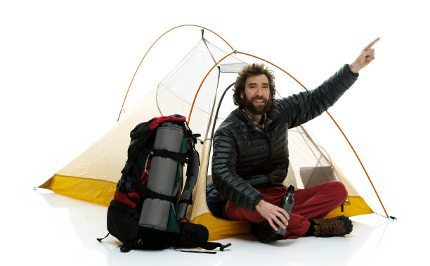 微笑的徒步旅行者坐在帐篷里，指着前方图片下载