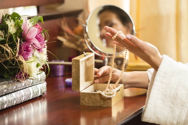 女士从首饰盒中挑选项链图片下载
