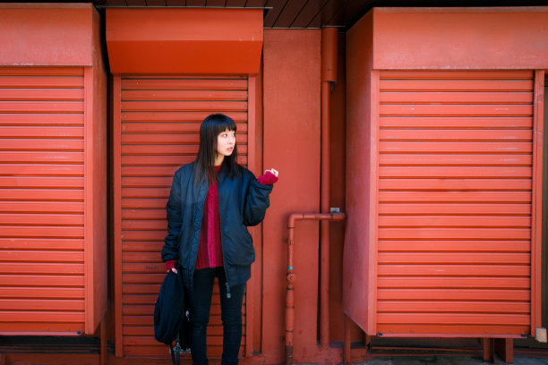 女孩站在红色的百叶窗前图片下载