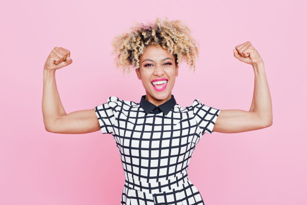 快乐的非洲裔美国年轻女子弯曲手臂素材图片