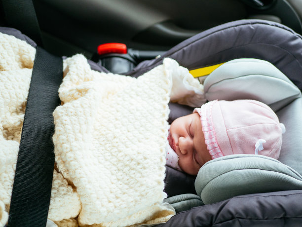 可爱的两周大的婴儿睡在汽车后座的汽车座椅上图片下载