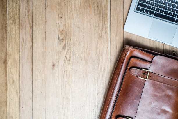 桌上放着笔记本和公文包。图片下载