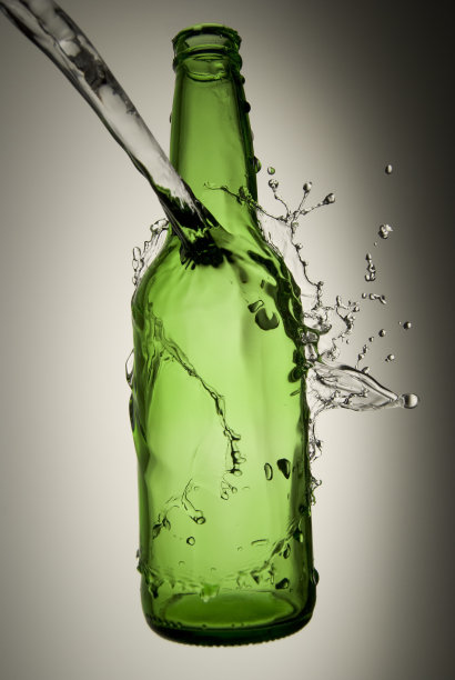 液体溅在绿色瓶子上图片下载