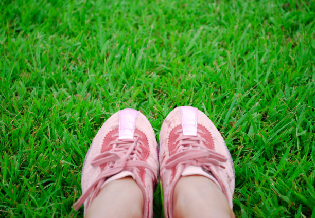 在茂盛的草地上穿着粉红色的少女运动鞋图片下载