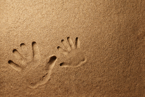 父亲和儿子的手印在沙子上图片下载