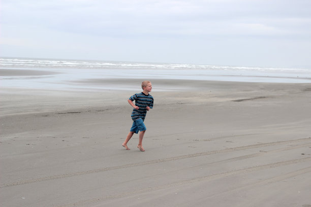 在海滩上跑步的男孩图片下载