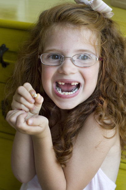 小女孩扶着她刚掉的牙图片下载