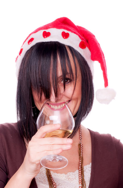 戴着圣诞帽喝着红酒的黑发女人图片下载