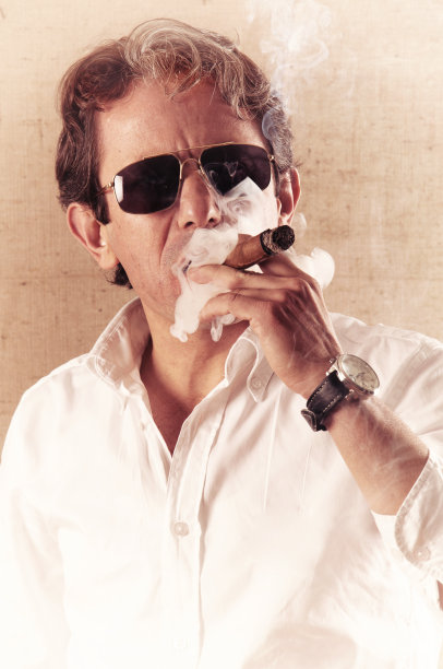 一个正在抽雪茄的成年人。图片下载