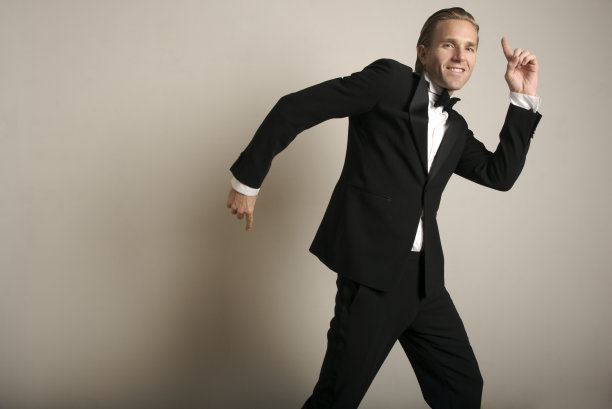 穿着燕尾服在室内跳舞的快乐年轻人图片下载