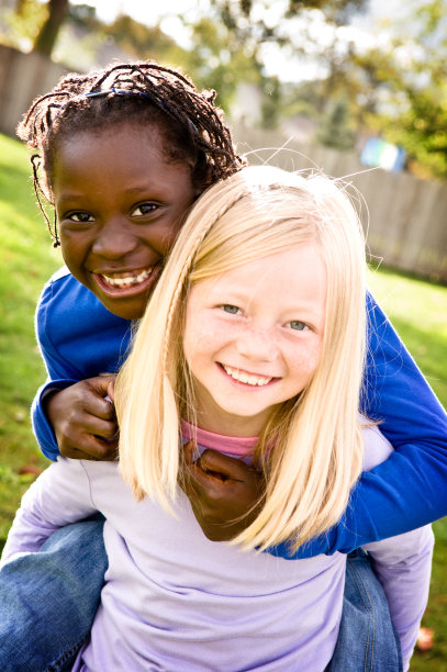 两个快乐的女孩微笑着骑在背上图片下载