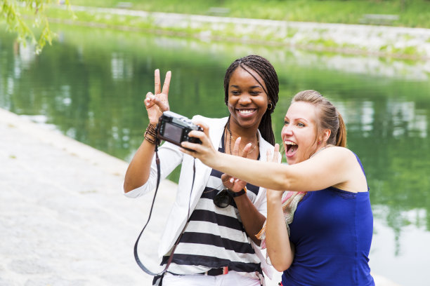 两个女孩在互相拍照，玩得很开心图片下载