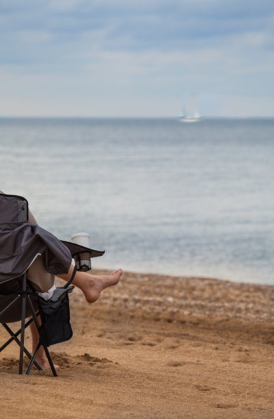 赤脚坐在沙滩椅上图片下载