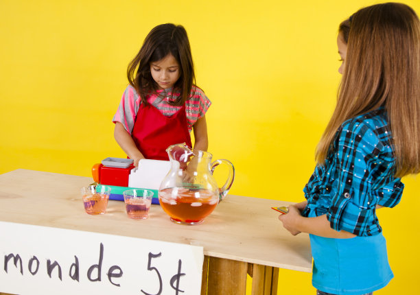 两个快乐的女孩，一个在小摊上买柠檬水图片下载