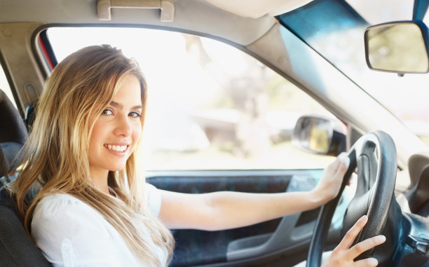 可爱的年轻女性在她的车里微笑图片下载