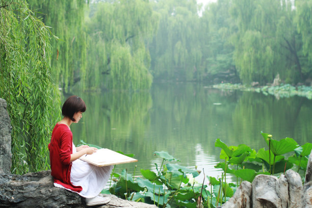 年轻的画家坐在湖边图片下载