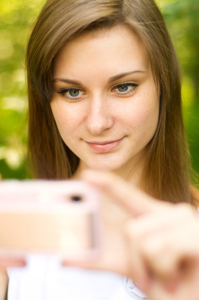 美丽的女孩在可爱的粉红色傻瓜相机拍照图片下载