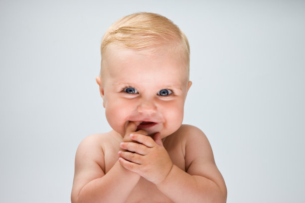 金发宝宝在白色背景前微笑图片下载