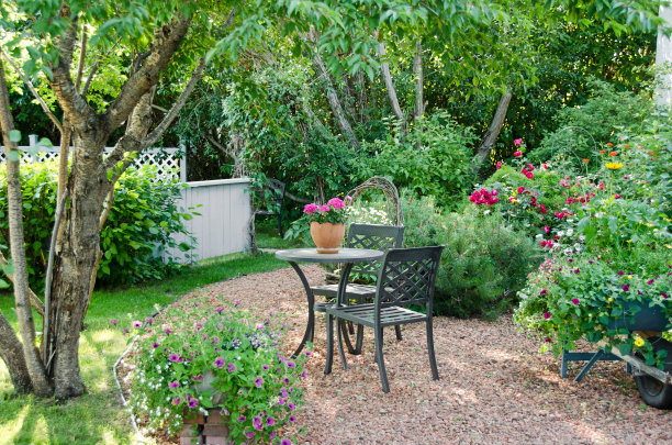 桌子和椅子在一个美丽的，多彩的户外花园。图片下载