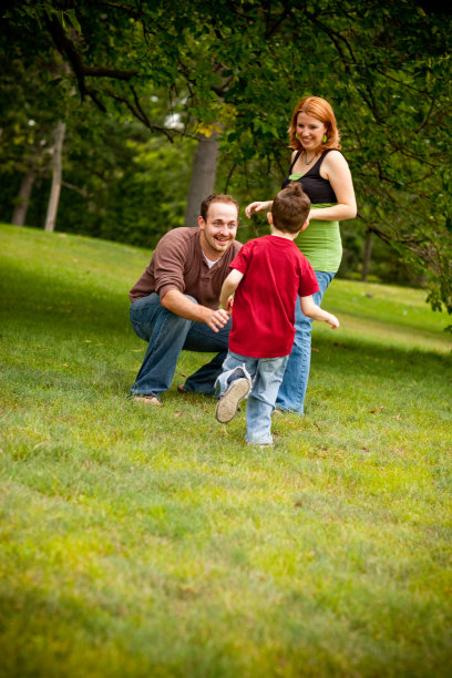 彩色图片，年轻的三口之家在公园里玩耍图片下载