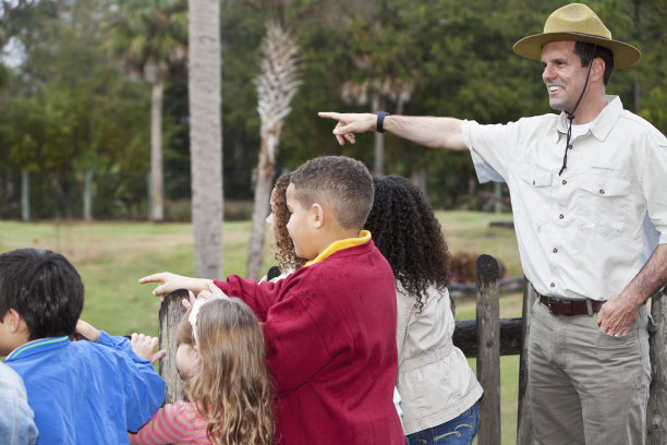 动物园管理员和一群孩子在动物展览素材图片