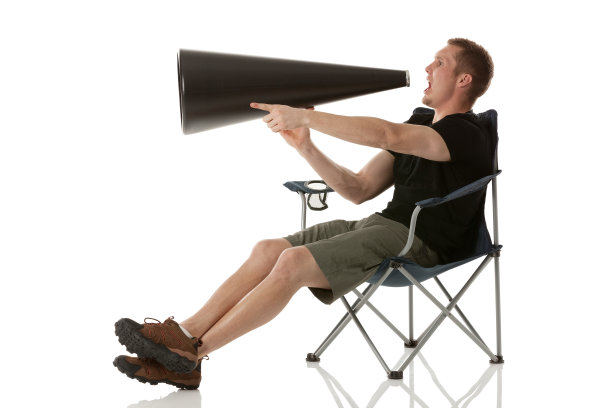 一个人坐在折叠椅上，用扩音器大喊大叫图片下载