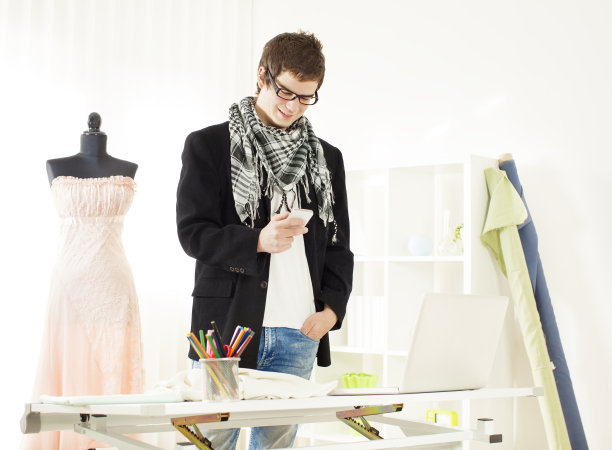 年轻男性时装设计师发短信。图片下载