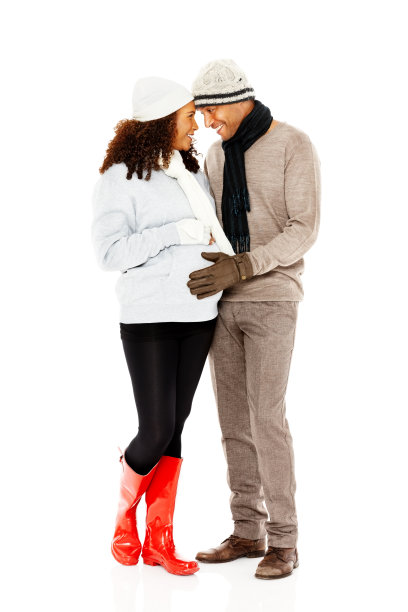 一对浪漫又有爱心的怀孕夫妇一起站在白色地毯上图片下载