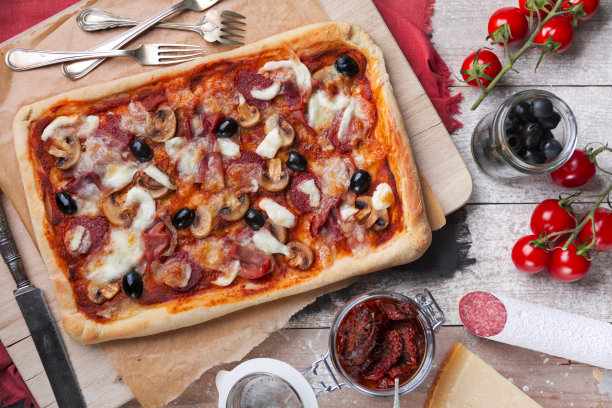 在质朴的桌子上放着自制的长方形披萨图片下载