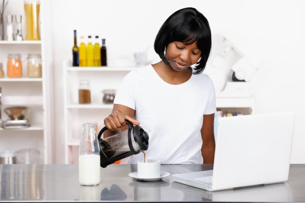非裔美国妇女往杯子里倒咖啡图片下载
