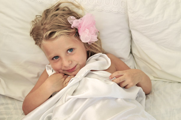 甜美的小女孩躺在床上图片下载