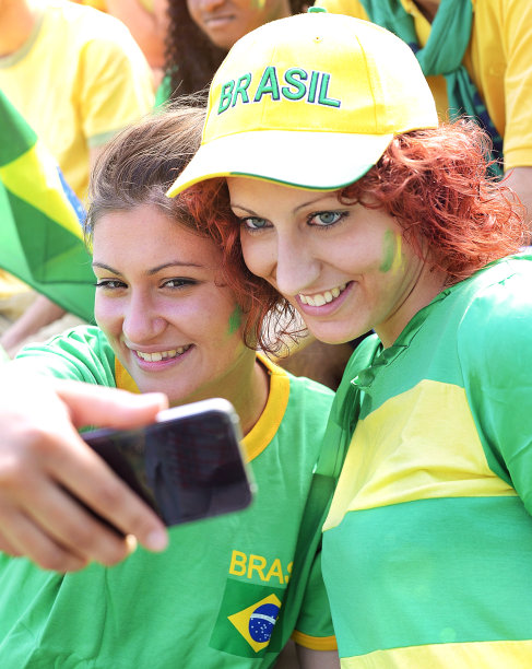 快乐的巴西球迷用手机拍照图片下载
