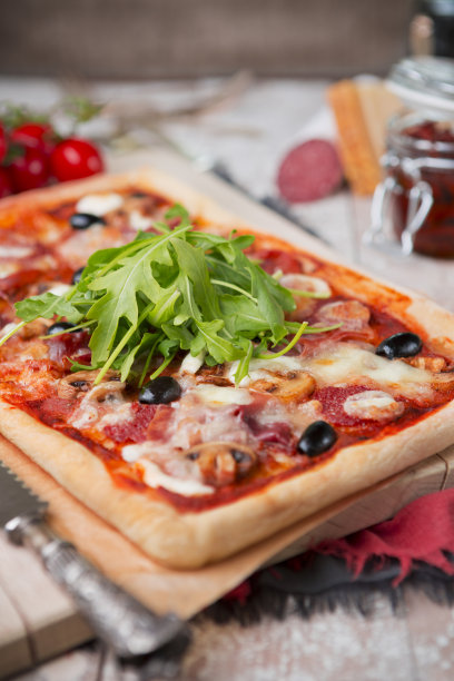 在质朴的桌子上放着自制的长方形披萨图片下载