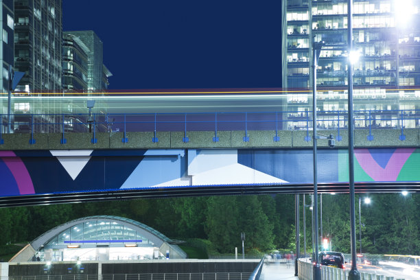 金丝雀码头是伦敦金融区，夜间有驶过的火车图片下载