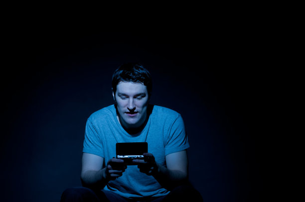 迷人的年轻人在暗室玩电子游戏图片下载