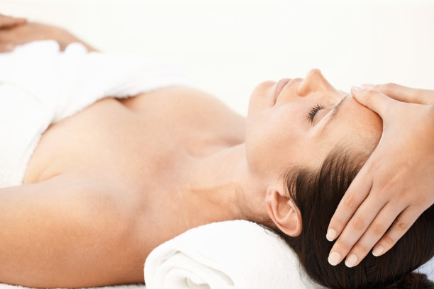 一个美丽的女人接受头部按摩的特写素材图片