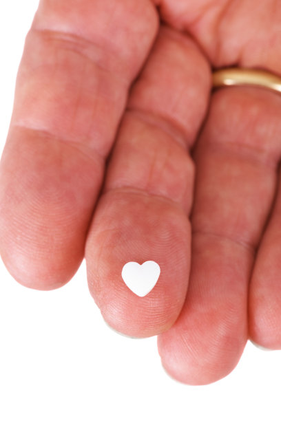 心脏形状的药丸在男人的指尖图片下载