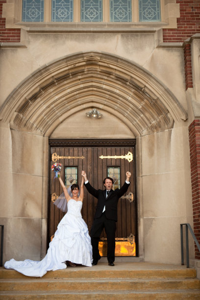 新婚夫妇举起双手庆祝他们的婚姻图片下载