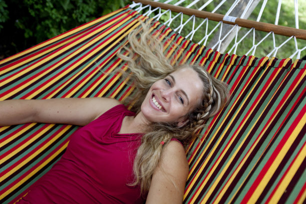 彩色吊床上的金发微笑女孩图片下载