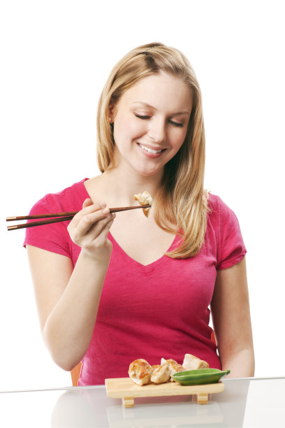 年轻女子吃中式点心锅贴饺子图片下载