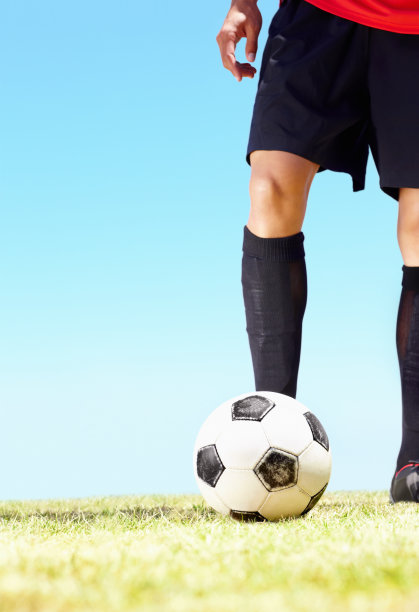 足球运动员在球场上踢足球的下部图片下载