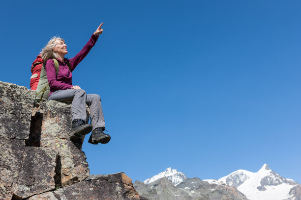快乐的女攀登者用手指着阿尔卑斯山图片下载